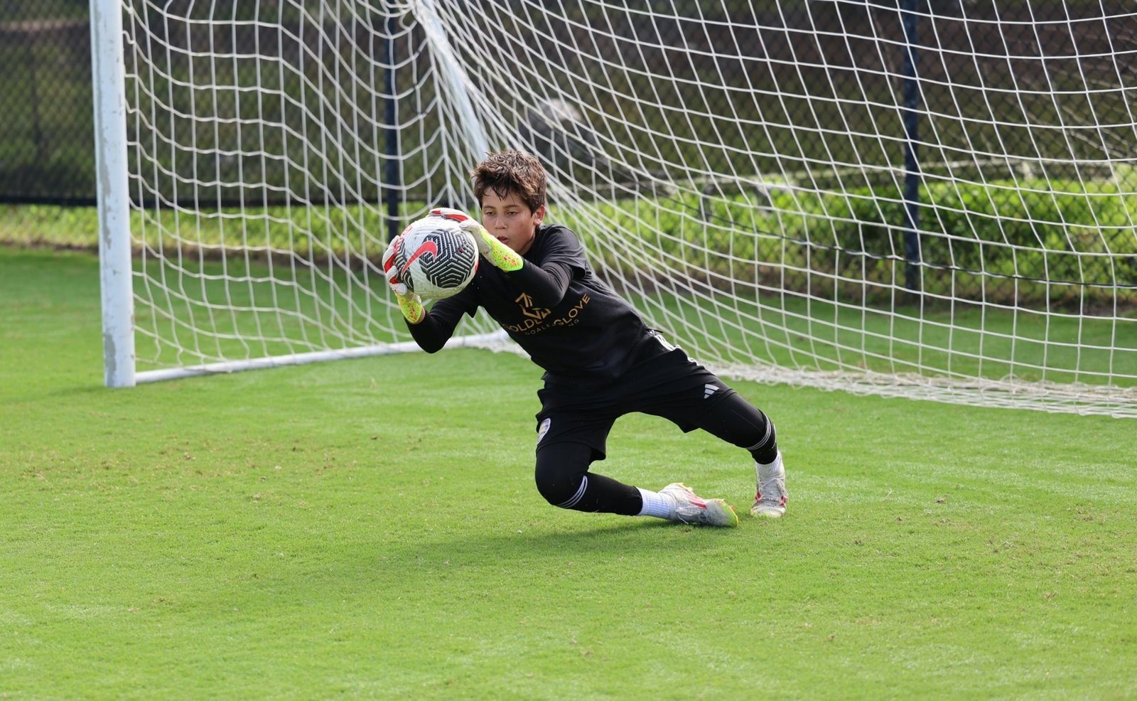 Young goalkeeper making a diving catch